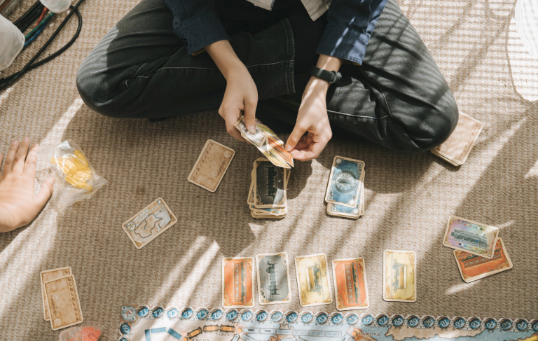 karty do gry leżące przed osobą siedzącą na podłodze